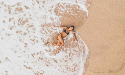 woman lying on the beach in the sea