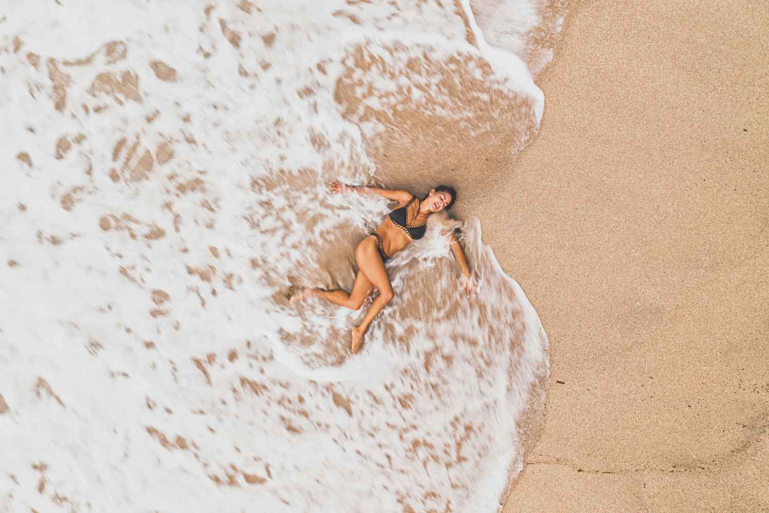 woman lying on the beach in the sea
